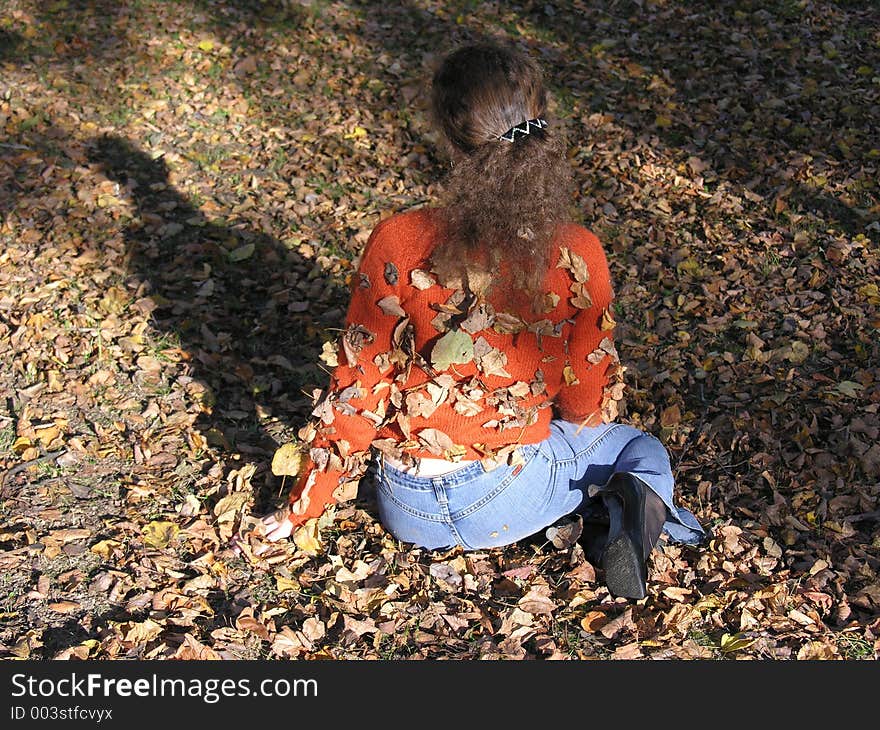 Girl with autumn leaves on her back