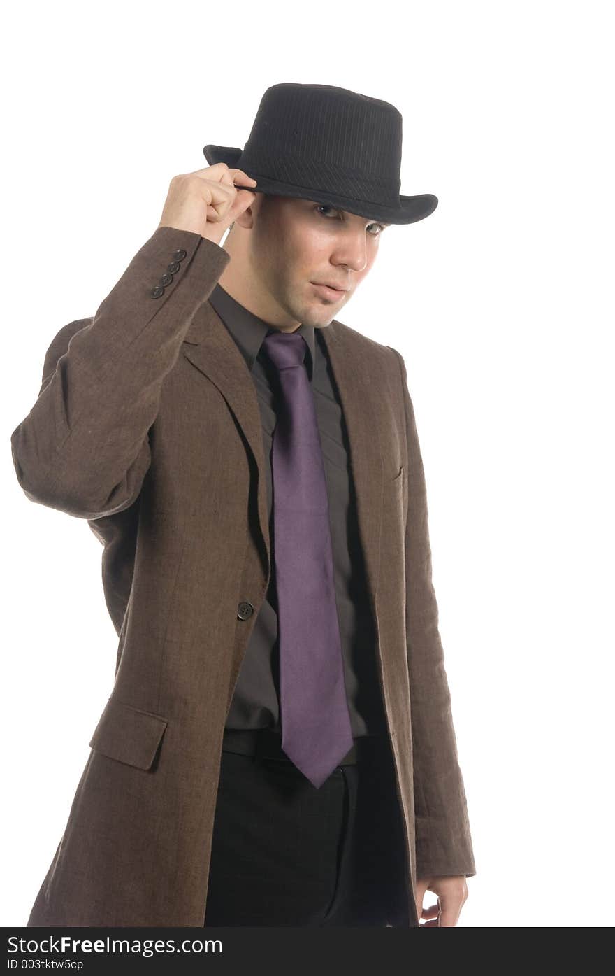 Slick businessman adjusting his hat, isolated on white