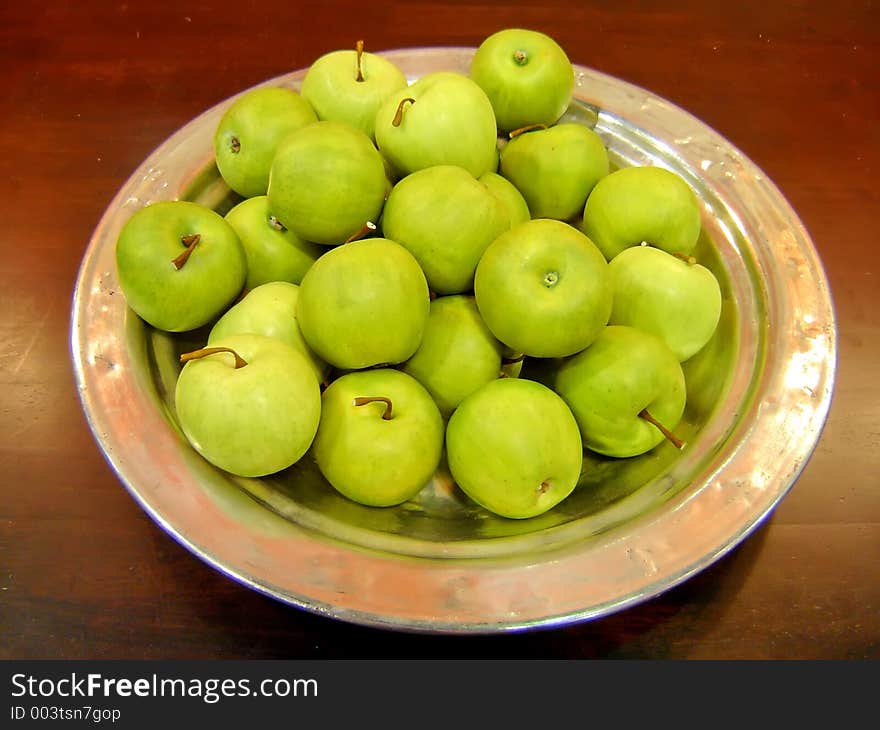 Green apples in metal plate