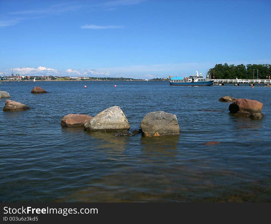 Sea landscape – sea, shallow, stones, ship and sky. Sea landscape – sea, shallow, stones, ship and sky