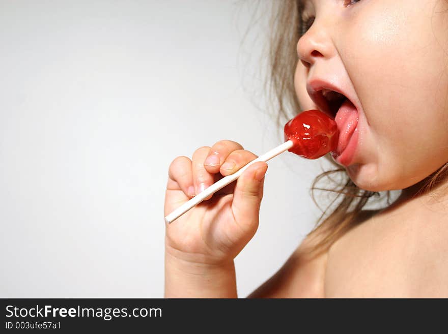 Young child enjoying a lollipop. Young child enjoying a lollipop