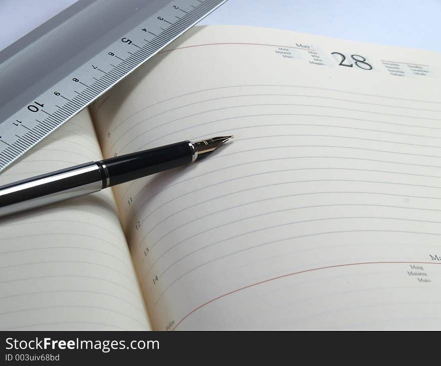 One classic pen and an aluminion rule on a white notepad. One classic pen and an aluminion rule on a white notepad