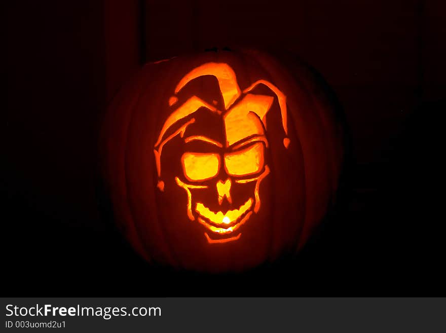 A jester carved from a pumpkin. A jester carved from a pumpkin