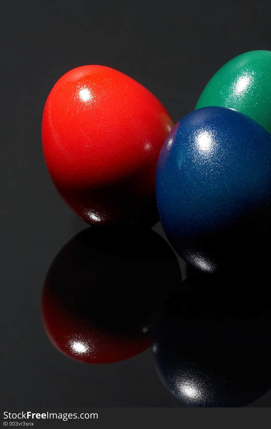 Three different coloured eggs on black background. Three different coloured eggs on black background