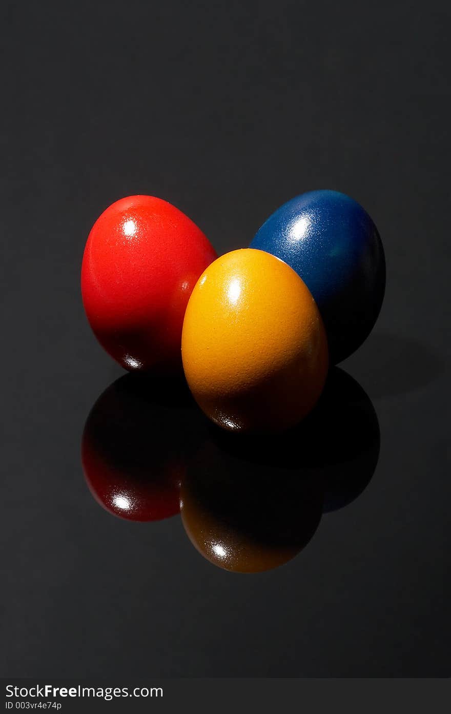 Three different coloured eggs on black background. Three different coloured eggs on black background