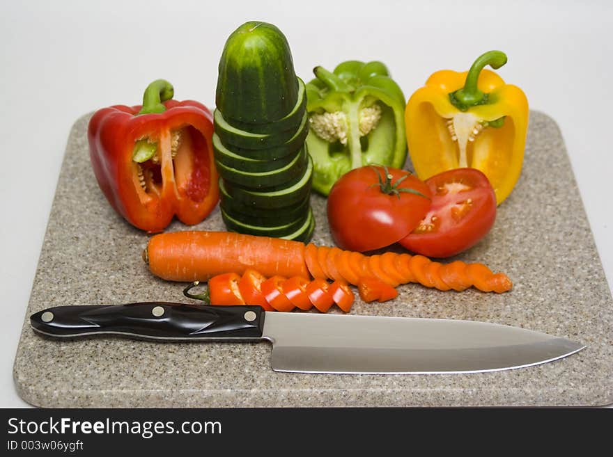 Cut vegetables on a cutting board with a knife.