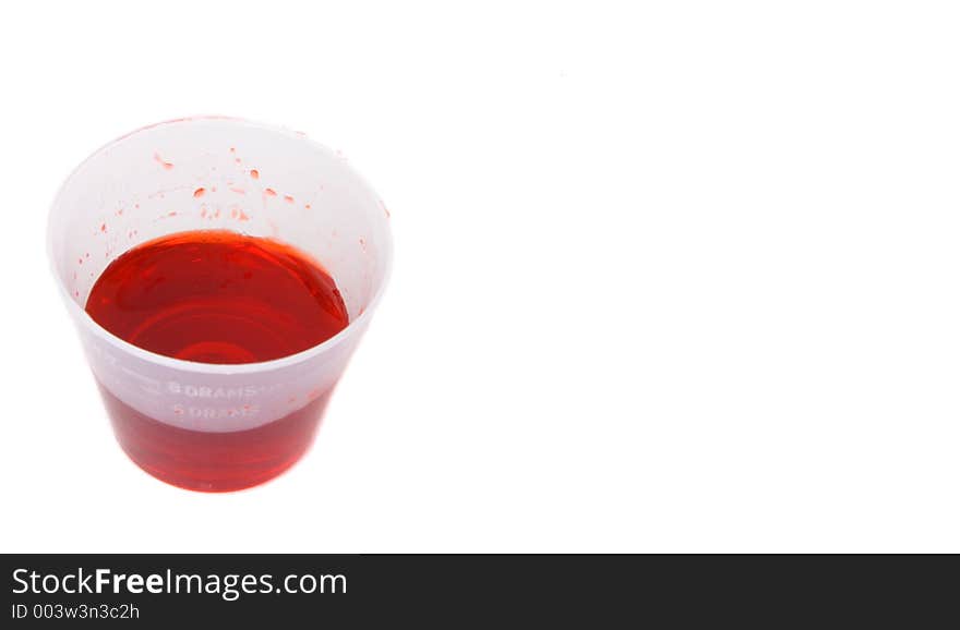 Small dose cup with cough syrup and copy space to the right