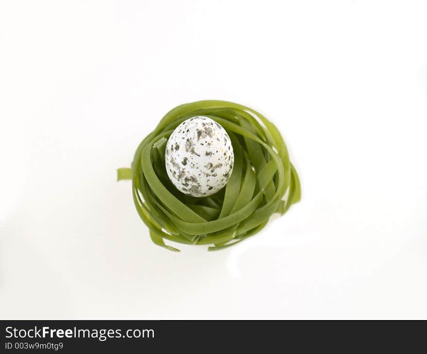 Green pasta nest with egg, white background. Green pasta nest with egg, white background