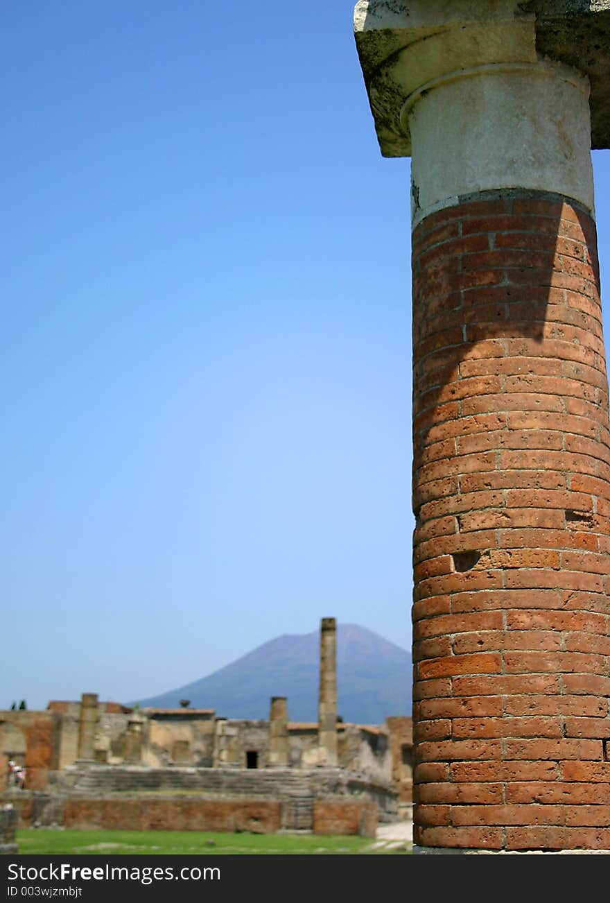 Focused column in foreground with ruins and volcano in background. Focused column in foreground with ruins and volcano in background