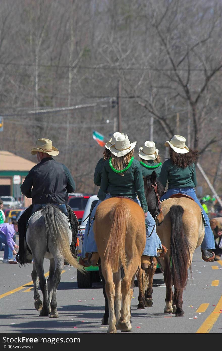 Cowboys & cowgirls riding horses with a wagon train thru town. Cowboys & cowgirls riding horses with a wagon train thru town