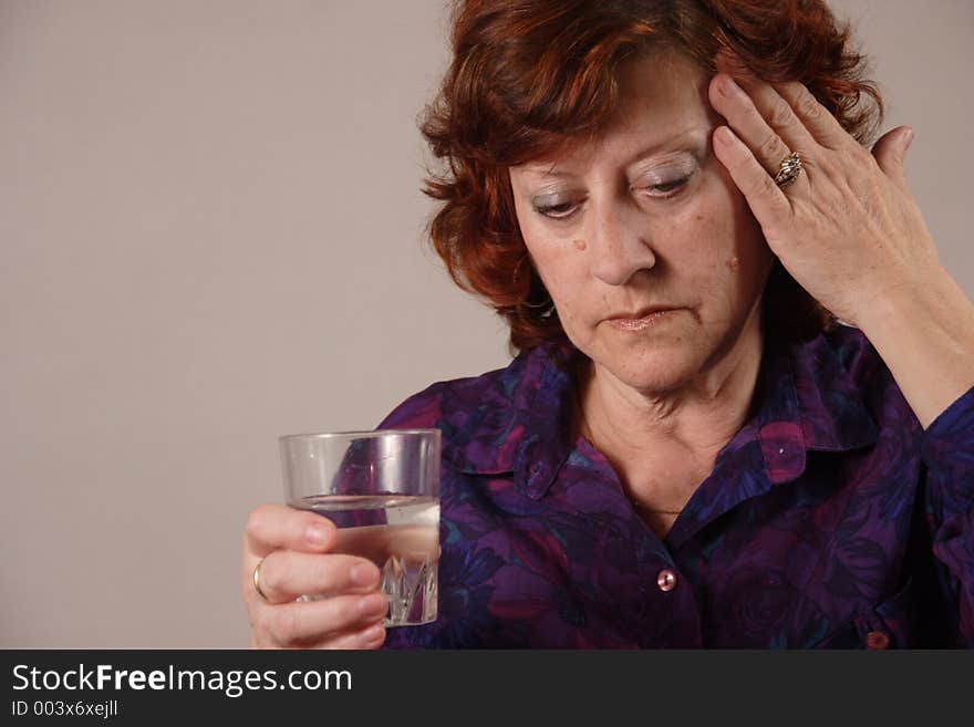 Senior woman. Headache and glass of water in a hand. Senior woman. Headache and glass of water in a hand.