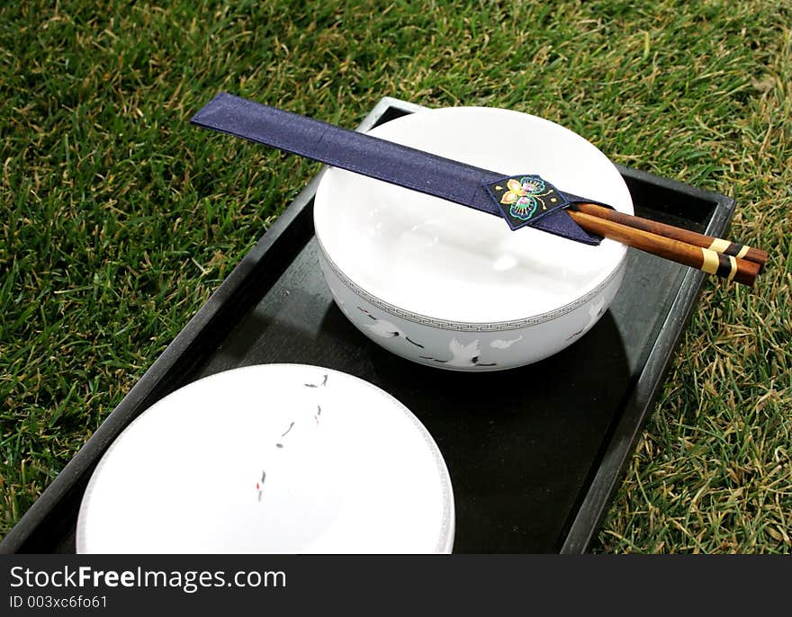 Chopsticks and bowl sitting on the grass. Chopsticks and bowl sitting on the grass