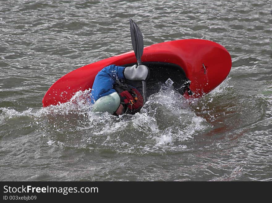 Lone kayaker practicing recovery from roll over. Lone kayaker practicing recovery from roll over