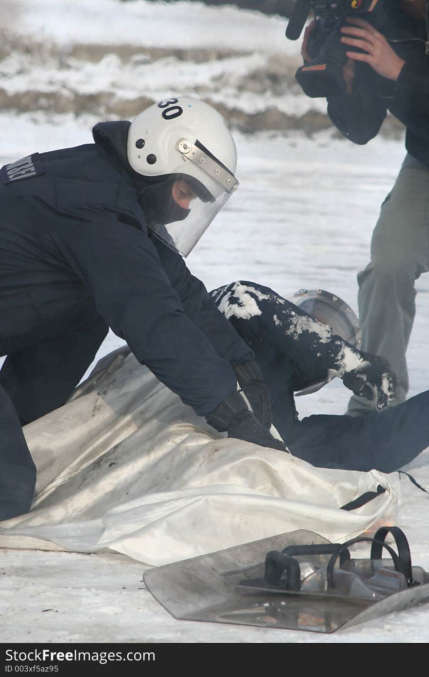 Man filming a policeman helping his coworker. Man filming a policeman helping his coworker