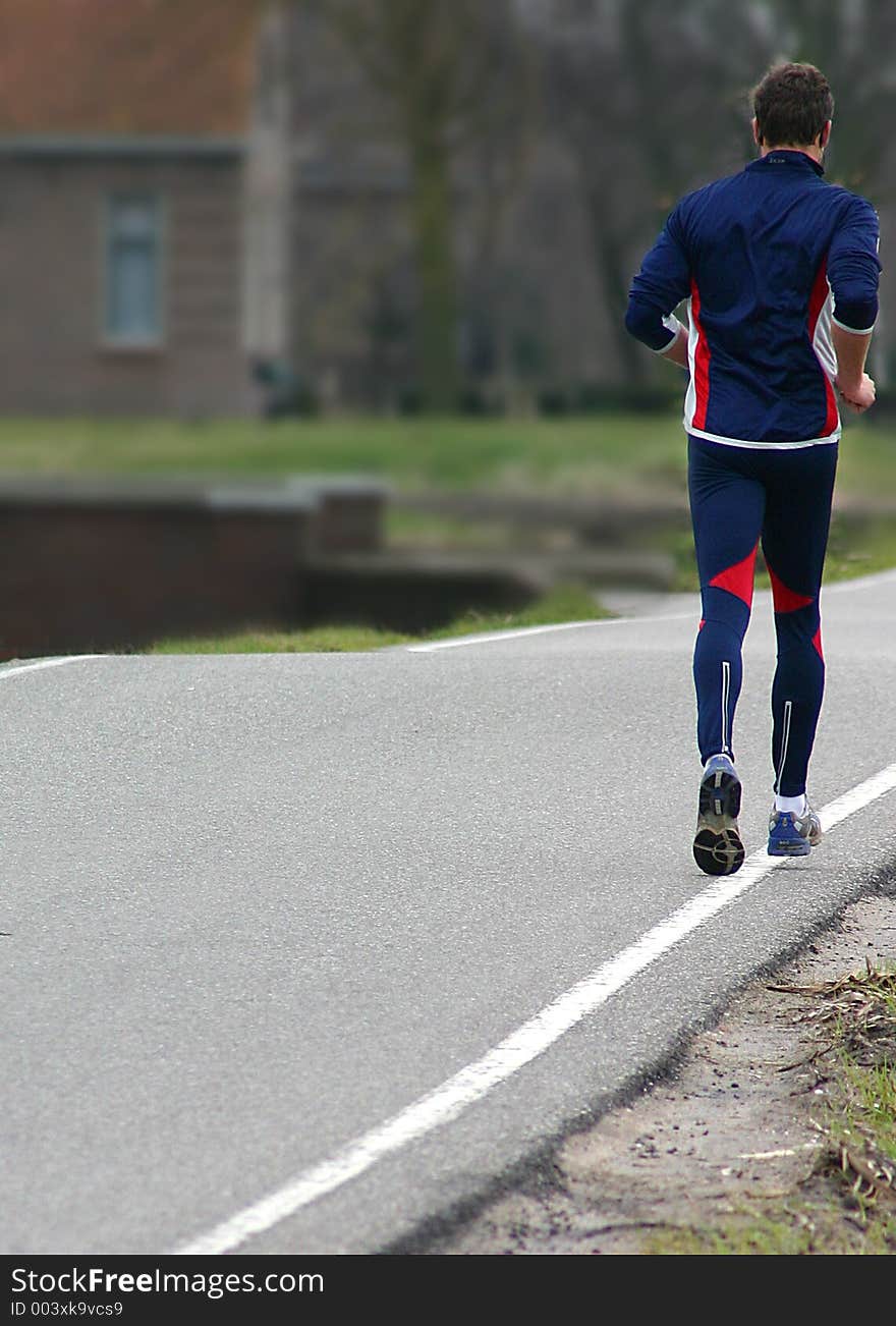 Male in track suit running on empty pathway. Male in track suit running on empty pathway