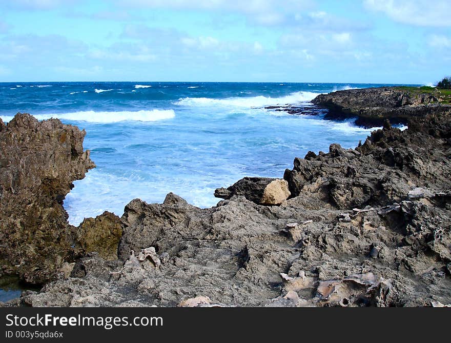 Blue tropical water breaks on rocks. Blue tropical water breaks on rocks.