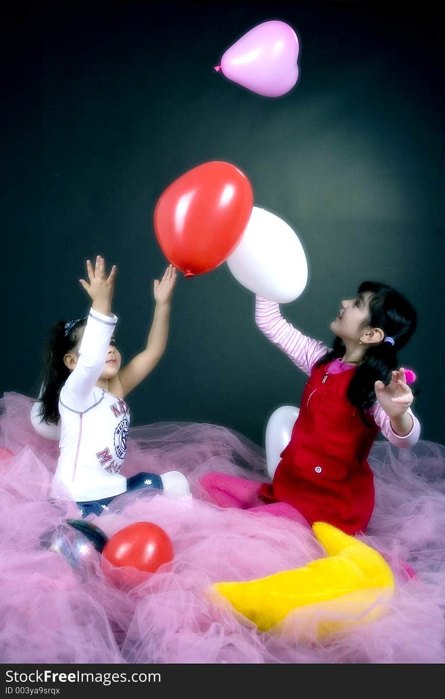 Young and beautiful girls playing with white and pink balloons. Young and beautiful girls playing with white and pink balloons