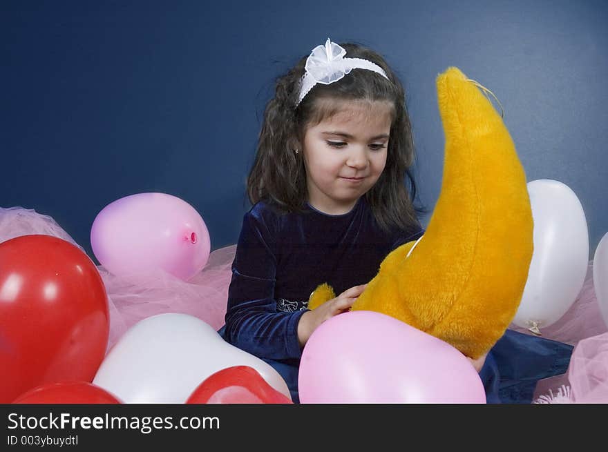 Sweet young girl playing with her plush moon