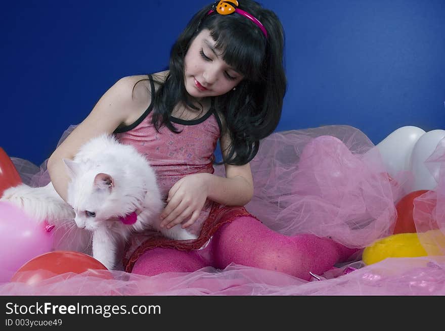 Pretty little girl playing with her white cat. Pretty little girl playing with her white cat