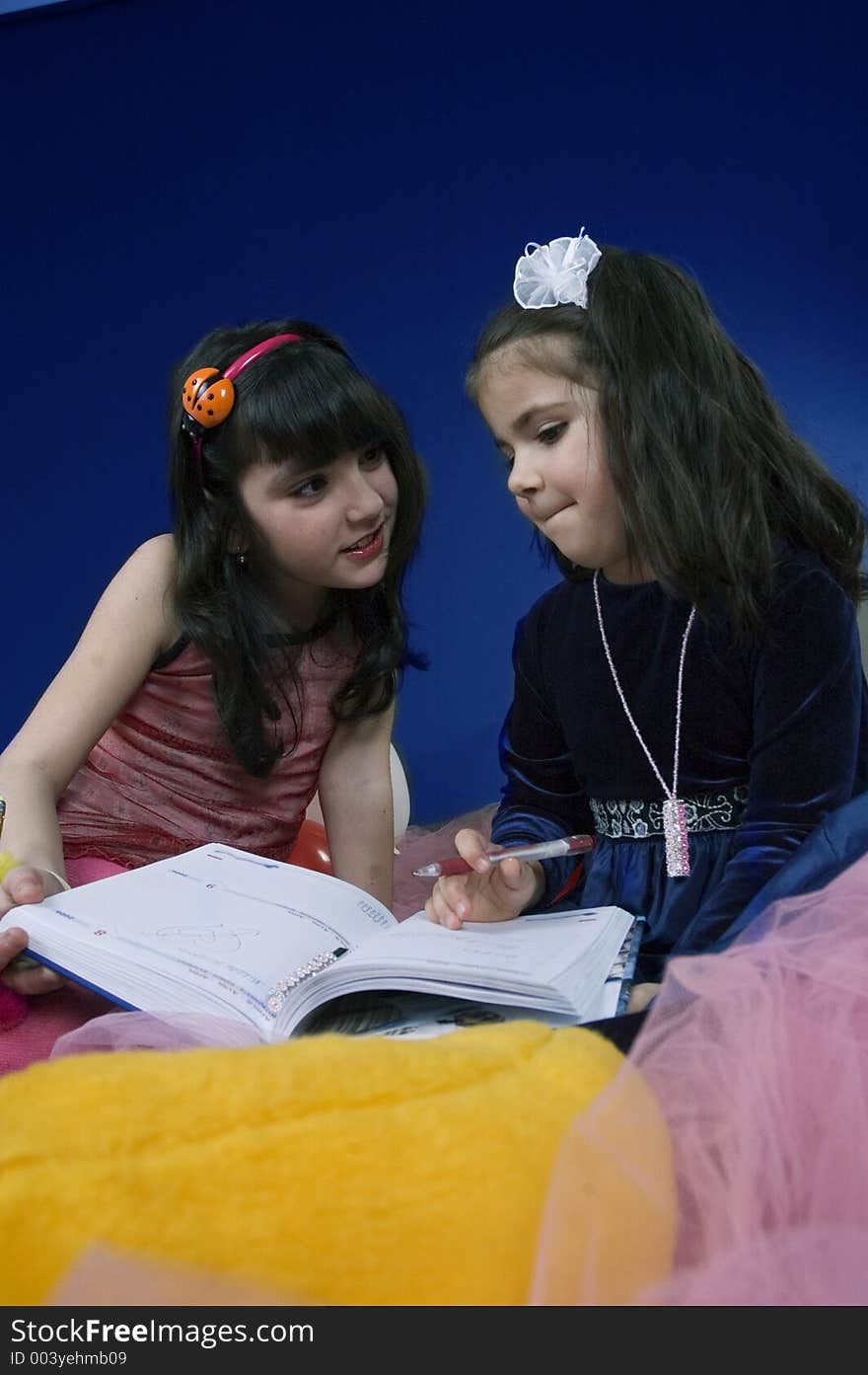 Little girls explaining each other how to write. Little girls explaining each other how to write