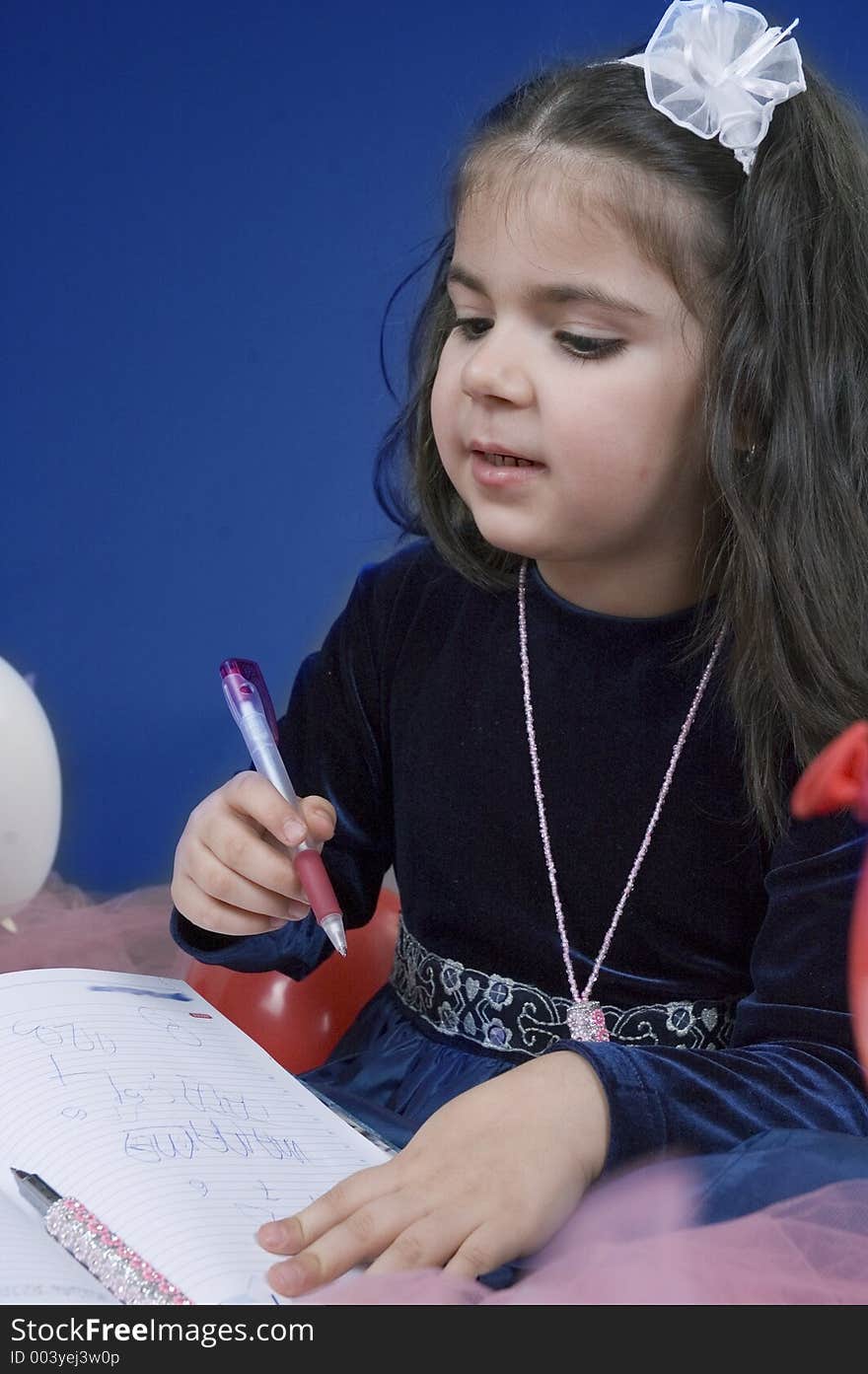 Little girl with a pen and agenda explaining something. Little girl with a pen and agenda explaining something