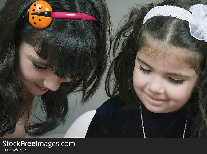 Two little girls focused on something. Two little girls focused on something