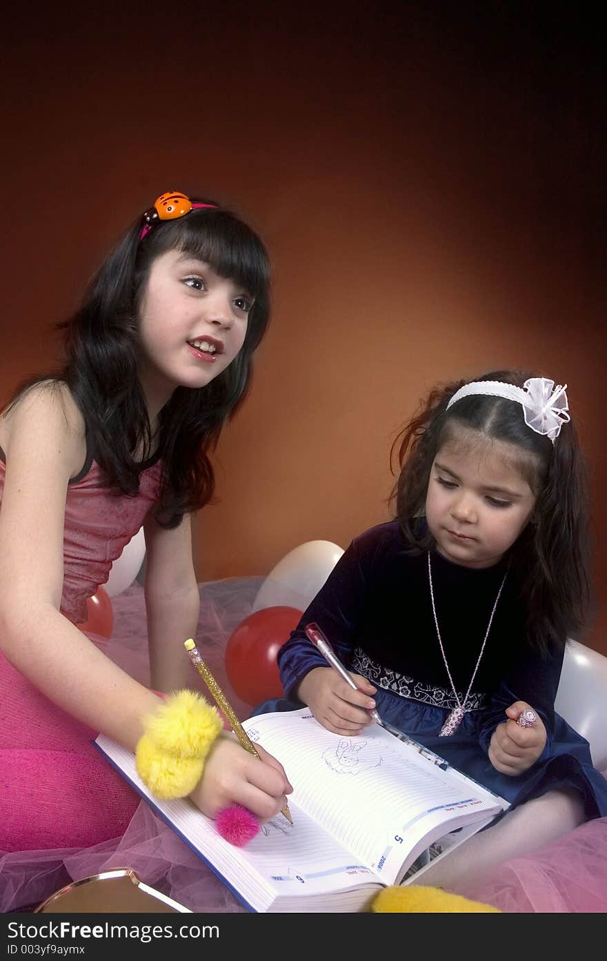 Two little girls writing in an agenda explaining to an auditorium. Two little girls writing in an agenda explaining to an auditorium