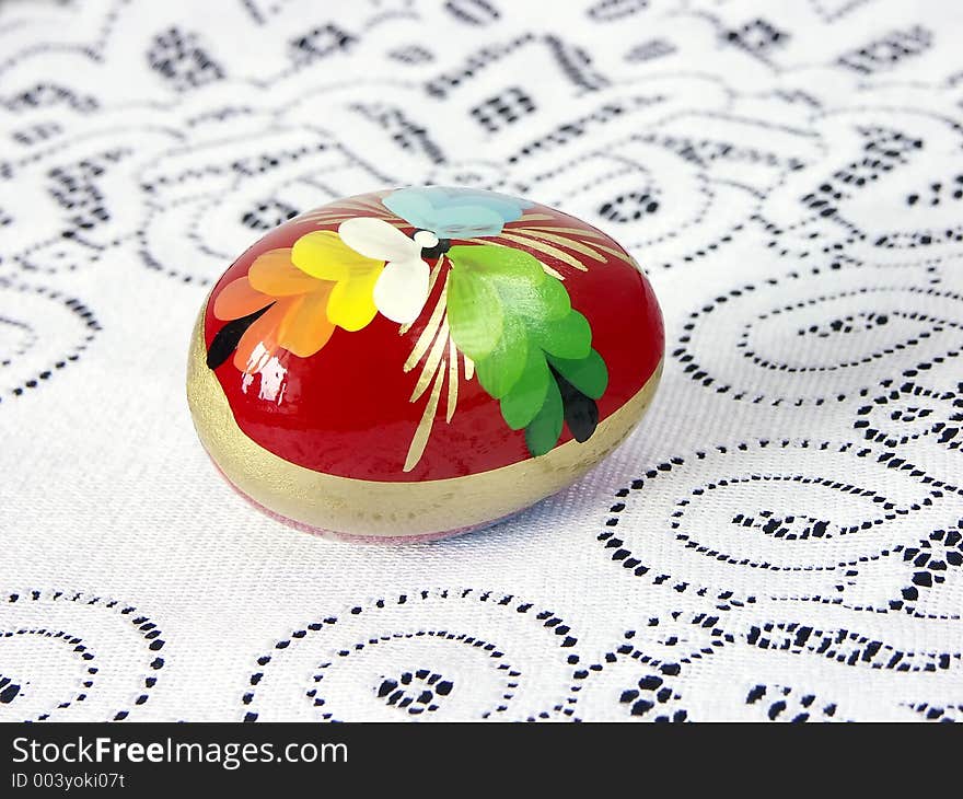 Painted easter egg on white knitted tablecloth. Painted easter egg on white knitted tablecloth