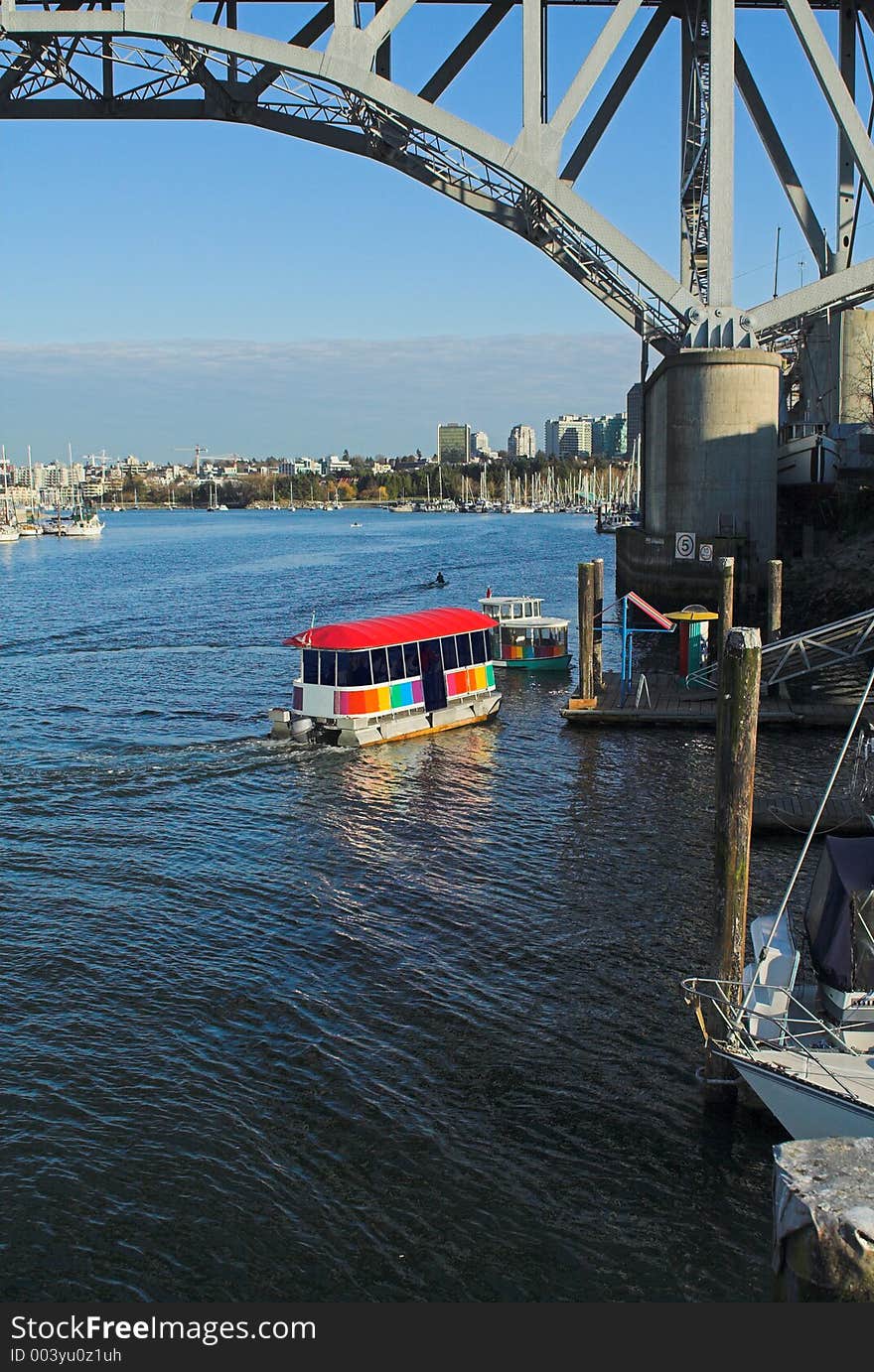 Small ferry under bridge