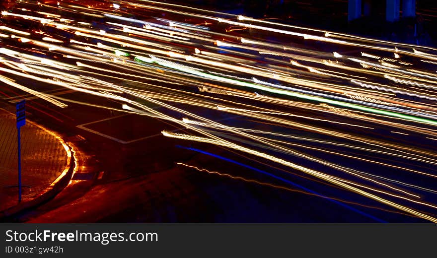 Several lights fly past a road sign. Several lights fly past a road sign.