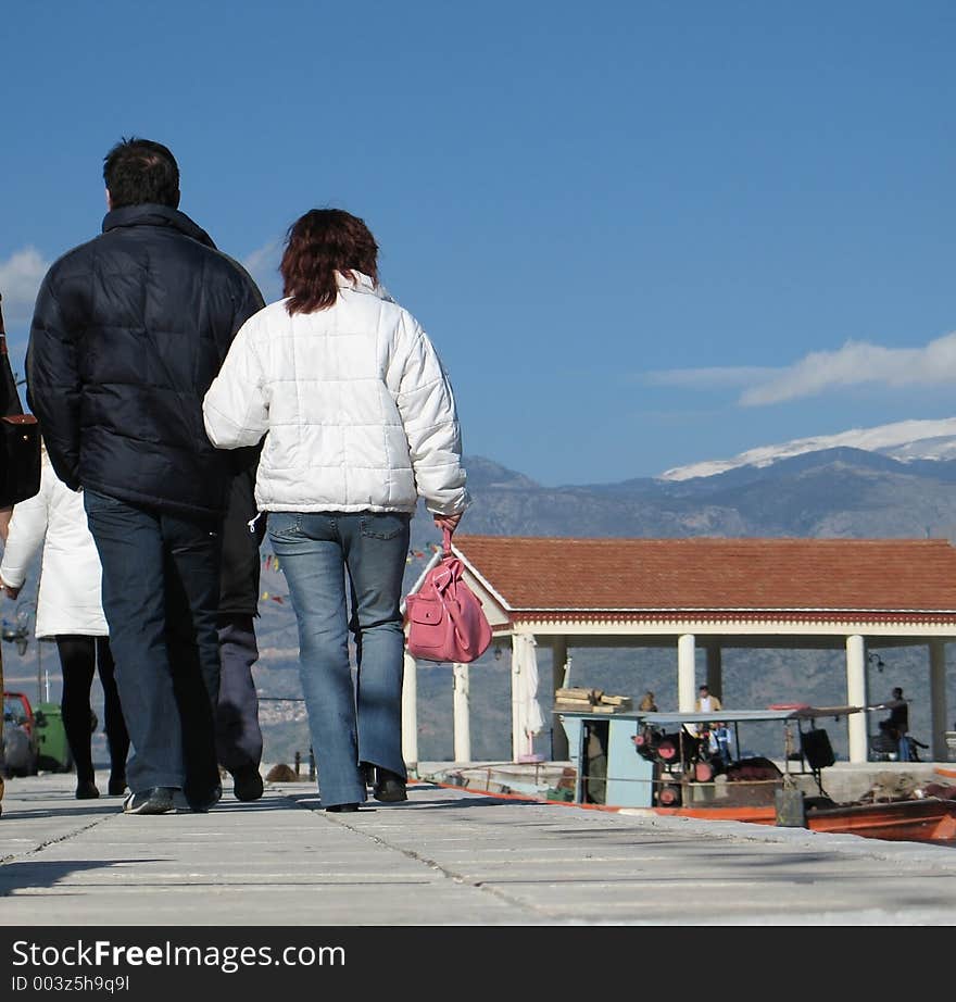 A couple walking on the pavement. A couple walking on the pavement