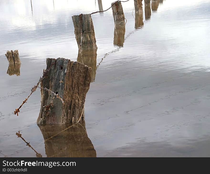 A fence once used to separate farm paddocks, now underwater in salt pans. A fence once used to separate farm paddocks, now underwater in salt pans