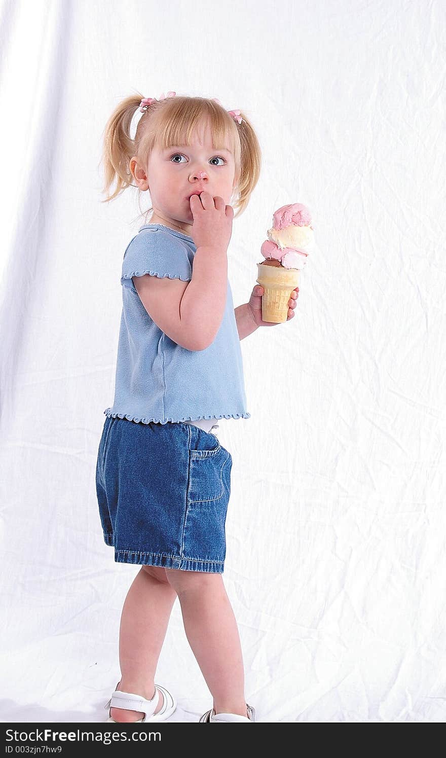 A girl holding an ice cream cone. A girl holding an ice cream cone.