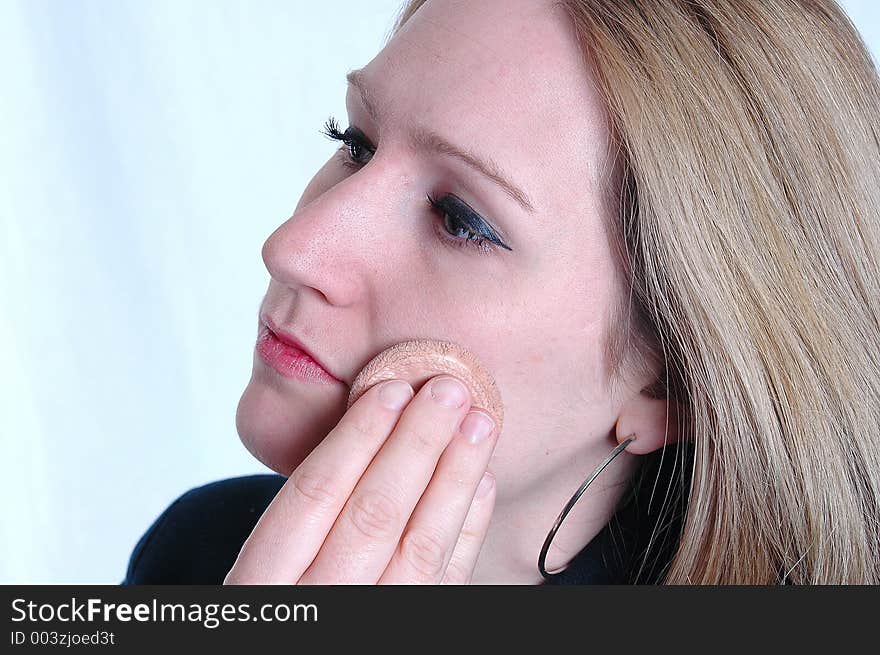 A woman applying make up. A woman applying make up.