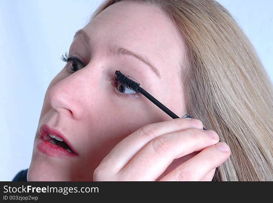 A woman applying make up. A woman applying make up.