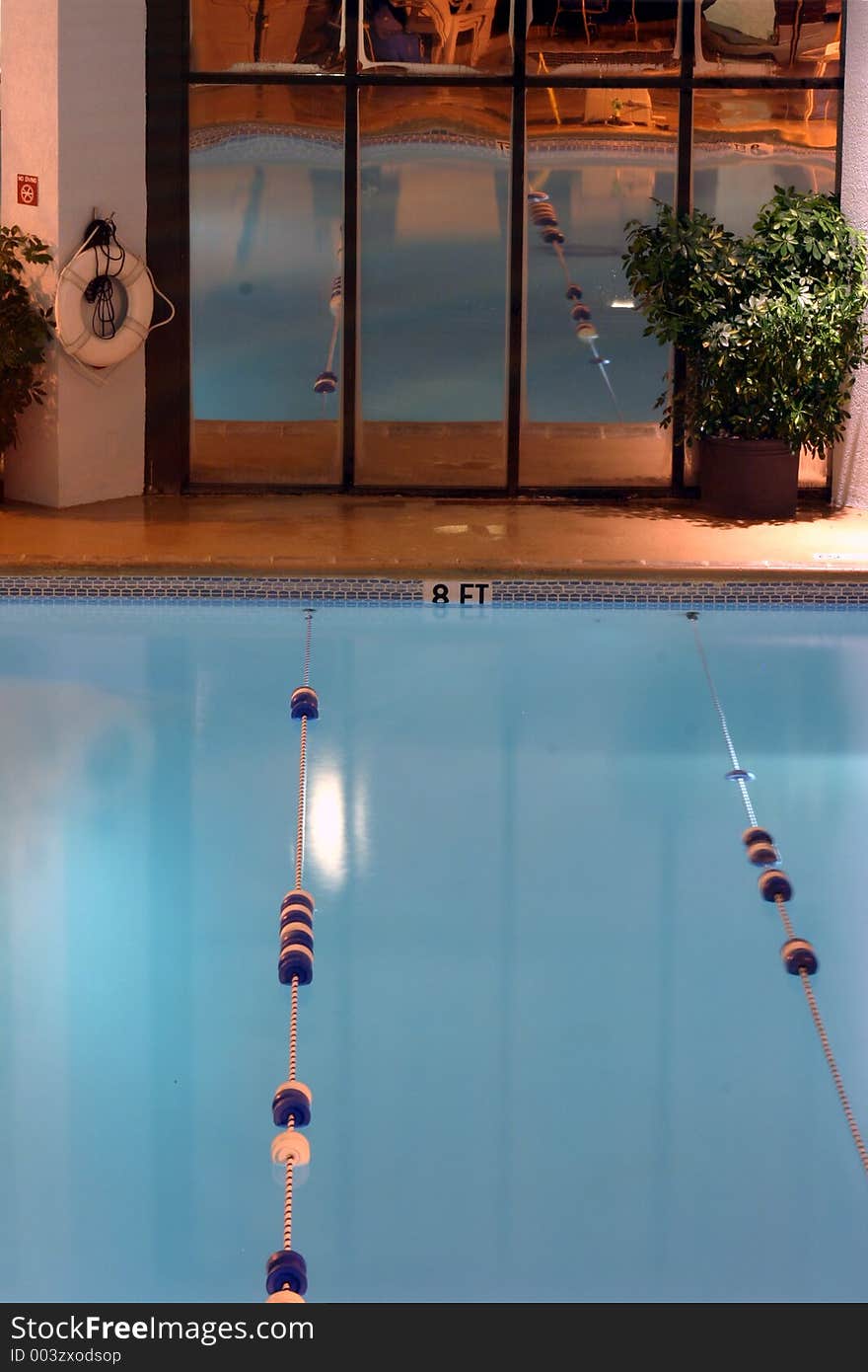 The deep end of the hotel pool with the rest of the pool reflected in the mirror windows. The deep end of the hotel pool with the rest of the pool reflected in the mirror windows