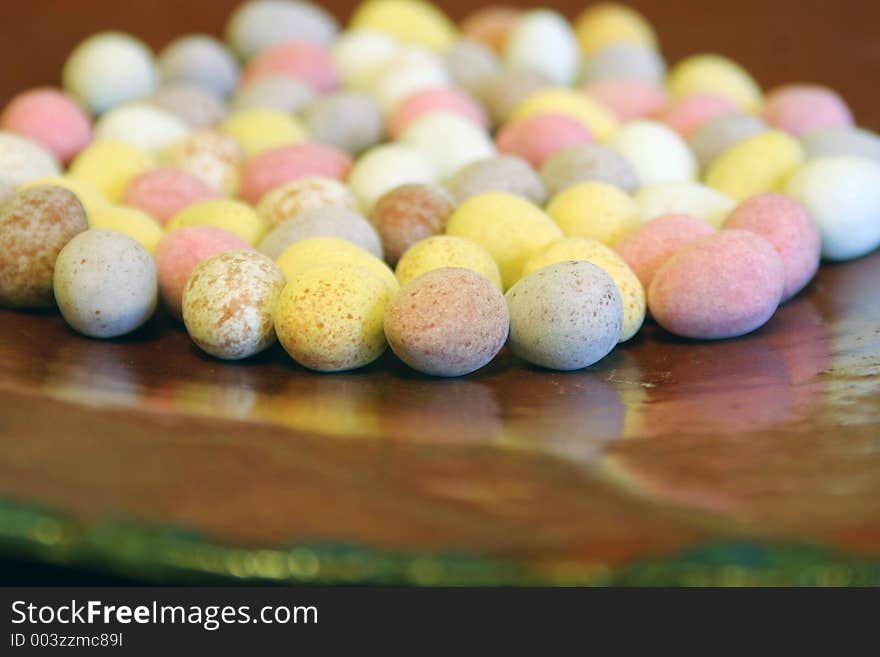 Mini candy chocolate eggs on a large brown dish