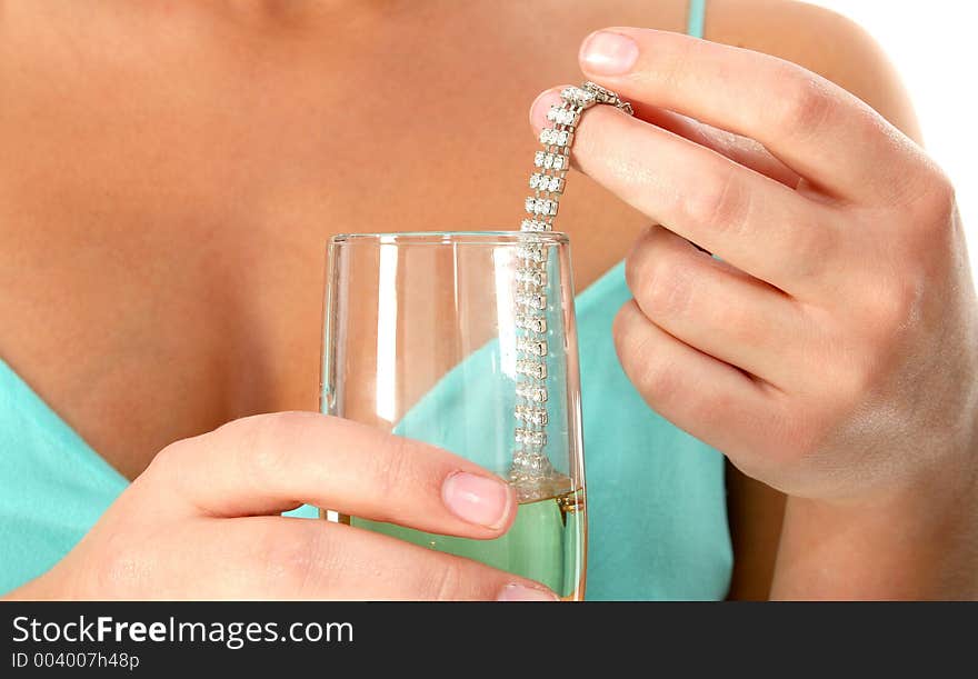 Woman's hand pulling diamond bracelet out of champagne glass. Woman's hand pulling diamond bracelet out of champagne glass.