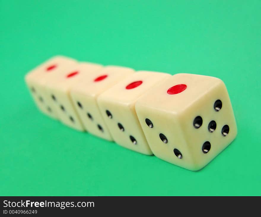 Perspective with five dice on green surface.Selective focus on the first die. Perspective with five dice on green surface.Selective focus on the first die.