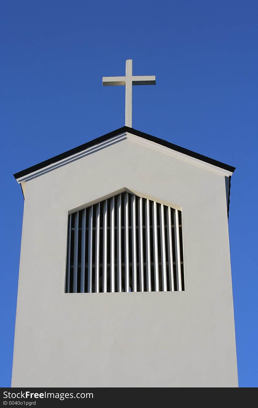 Cross and church roof against a blue sky