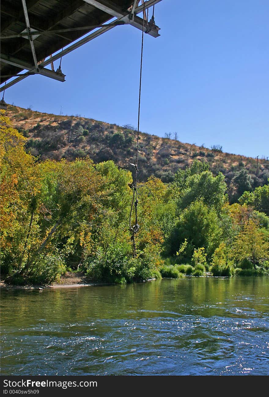 A swing rope hangs from a bridge promising swimming fun in the local swimming hole on the Kern River, Ca. A swing rope hangs from a bridge promising swimming fun in the local swimming hole on the Kern River, Ca.