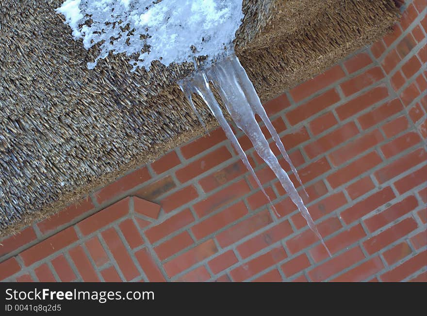 Icicles hanging from thatched roof. Icicles hanging from thatched roof