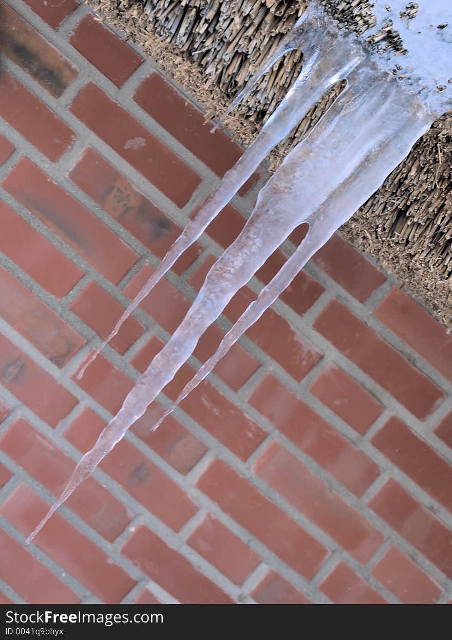 Icicles hanging from thatched roof top. Icicles hanging from thatched roof top