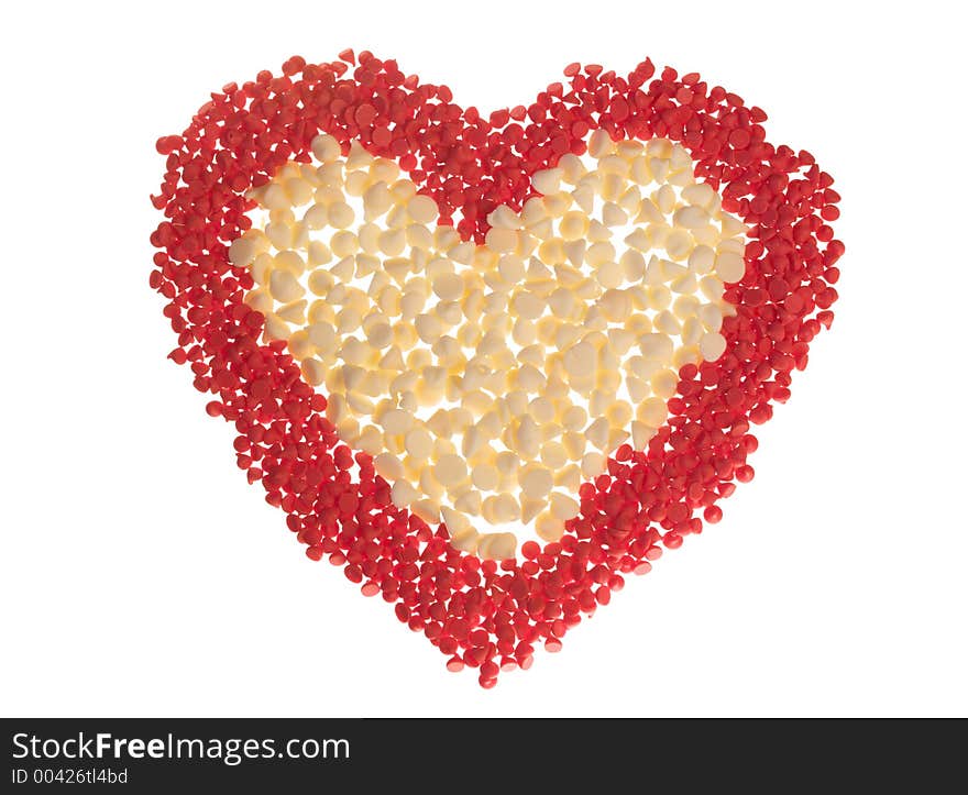 Red (cherry) and white chocolate baking chips arranged into a heart shape and isolated on white. Red (cherry) and white chocolate baking chips arranged into a heart shape and isolated on white.