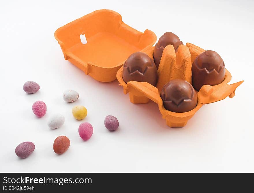 Chocolate eggs in an egg box with miniature sugar coated eggs. Chocolate eggs in an egg box with miniature sugar coated eggs