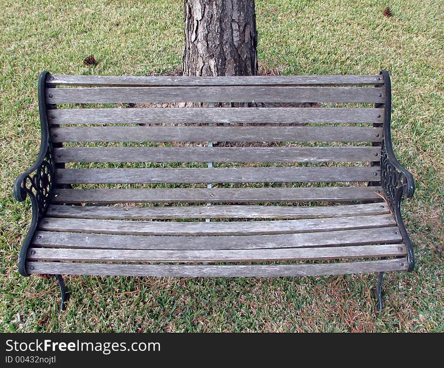 Garden chair in the middle of grass with a tree in the background. Garden chair in the middle of grass with a tree in the background