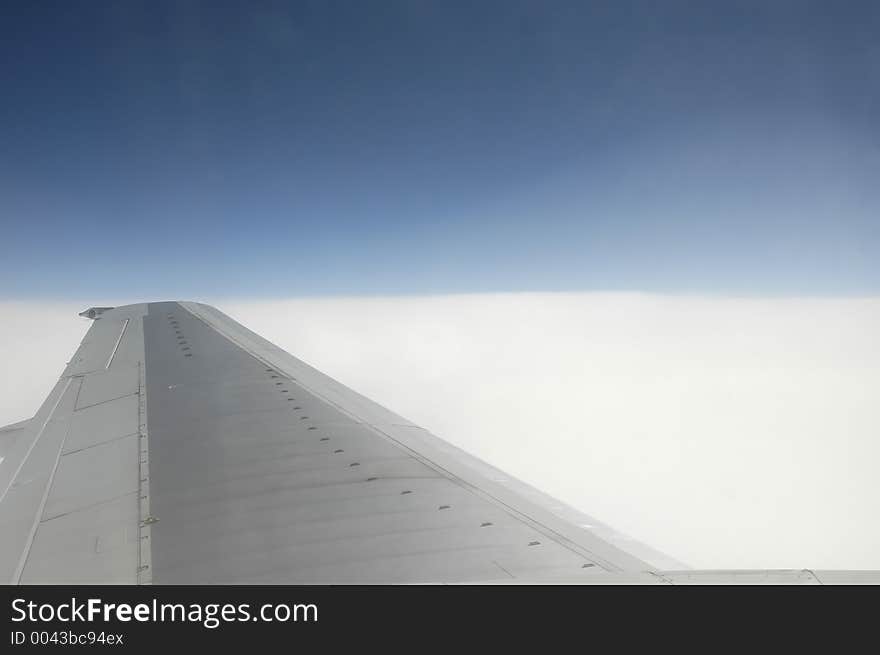 Wing over blue sky and clouds