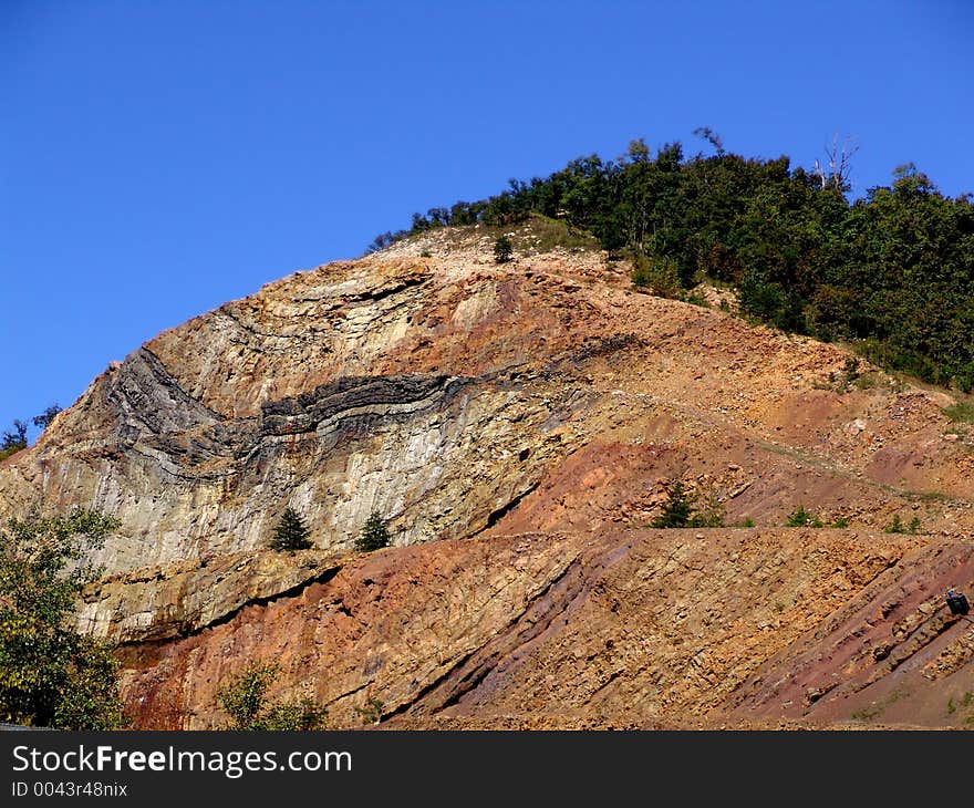 Cut rock - mountain with trees on top. Cut rock - mountain with trees on top