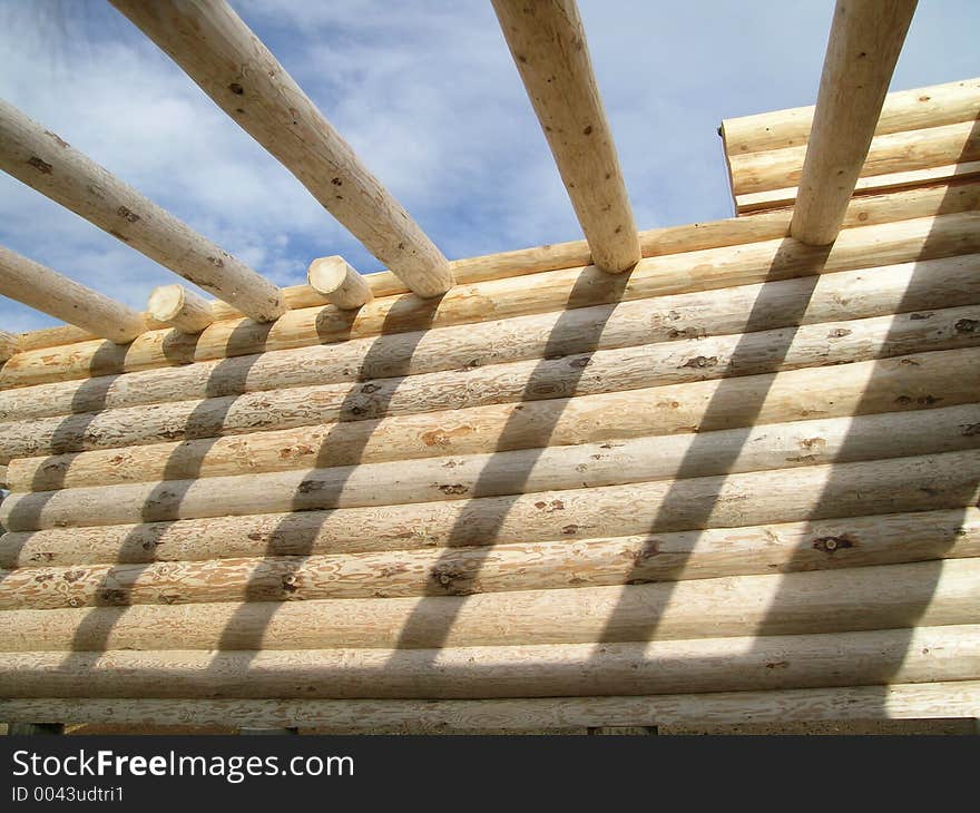 Interior wall and initial roof beams of a log cabin under construction. Interior wall and initial roof beams of a log cabin under construction