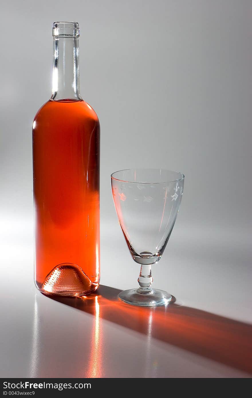 Dramatic studio light on a bottle of wine and glass. Dramatic studio light on a bottle of wine and glass